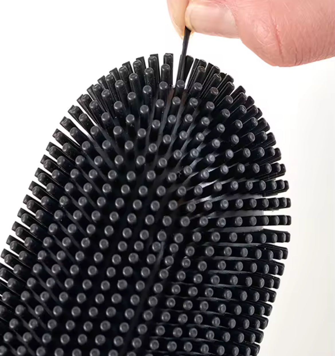 Stainless steel base toilet brush from Problems Solved standing next to a toilet for cleaning and sanitation.
