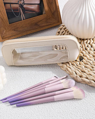 Small clear leather travel makeup bag with transparent design, featuring compartments for makeup brushes and cosmetics by Problems Solved.