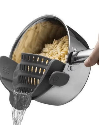 Adjustable silicone clip-on drainer for pots, pans, and bowls by Problems Solved, shown attached to a kitchen dish.