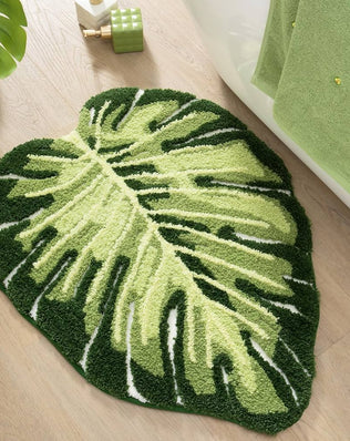 Green Monstera leaf bathroom rug, tropical plant-shaped bath mat by Problems Solved, soft shower mat for bathroom decor