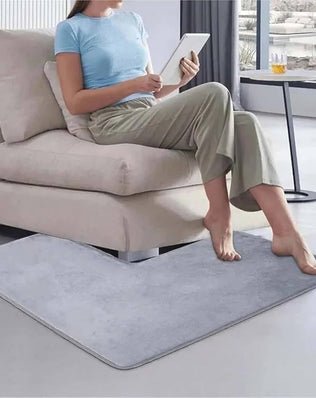 Soft coral fleece shaped bath mat by Problems Solved, non-slip corner shower rug for bathroom floor comfort and safety.