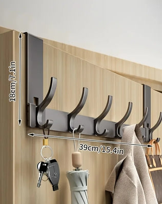 Bathroom shower storage rack by Problems Solved, made of space aluminum, with towels hanging, easy to install in a modern bathroom.
